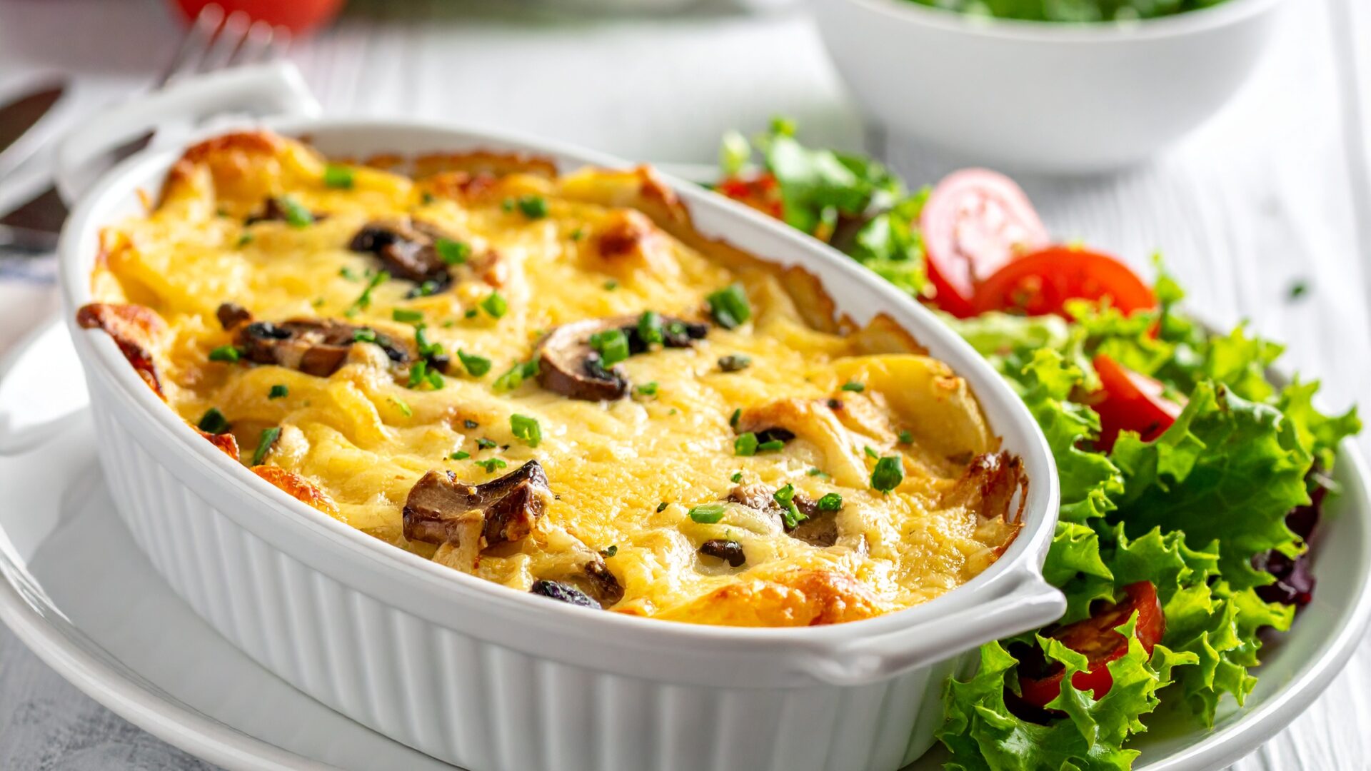 Gratin de pommes de terre, champignons, fromage et salade verte