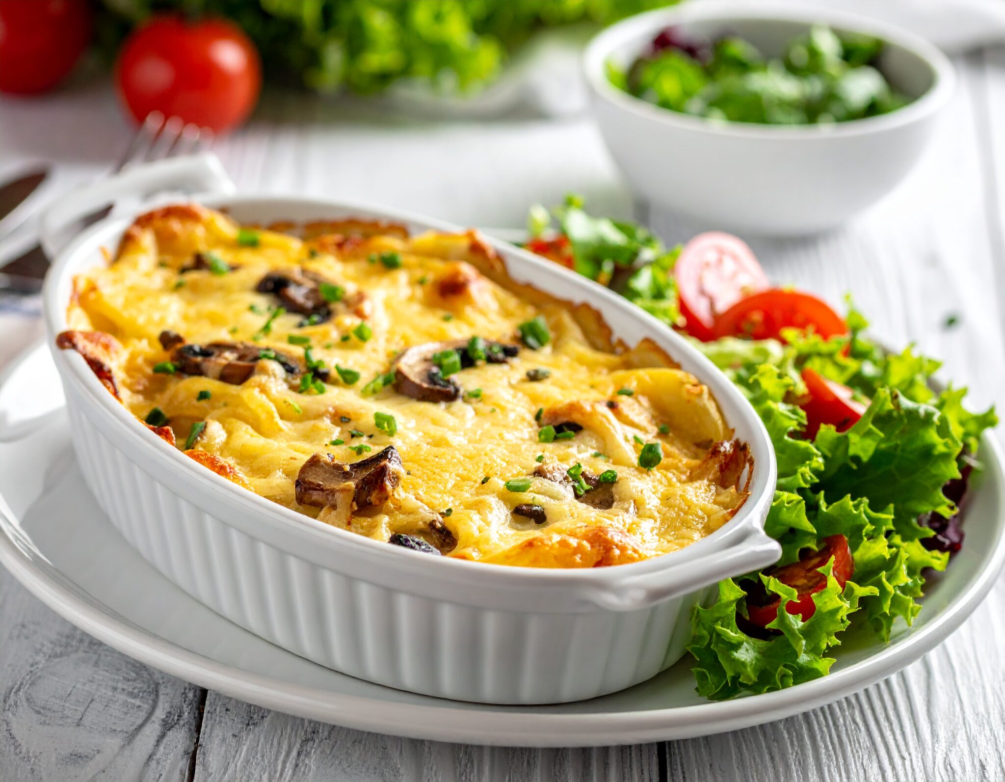 Gratin de pommes de terre, champignons, fromage et salade verte